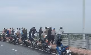 Gia đình và người dân vẫn đợi trên thành cầu để ngóng tin cuộc tìm kiếm - Ảnh: Hoàng Long
