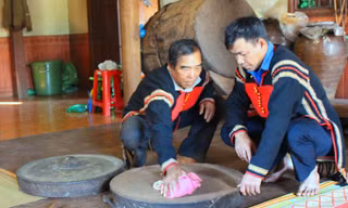 Ông Y Môi (bìa trái) bên chiếc chiêng cái của gia đình 