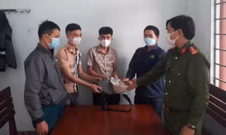 Anh Lê Văn Chung (thứ 2 từ phải sang) bàn giao số tiền nhặt được cho người mất - ảnh Huyền Oanh 