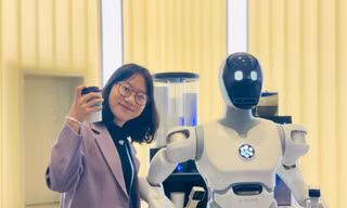Phóng viên Tân Hoa Xã Wang Xiansi giới thiệu bằng tiếng Việt về robot hình người pha cà phê từ A tới Z. Ảnh: Tư Hiền.