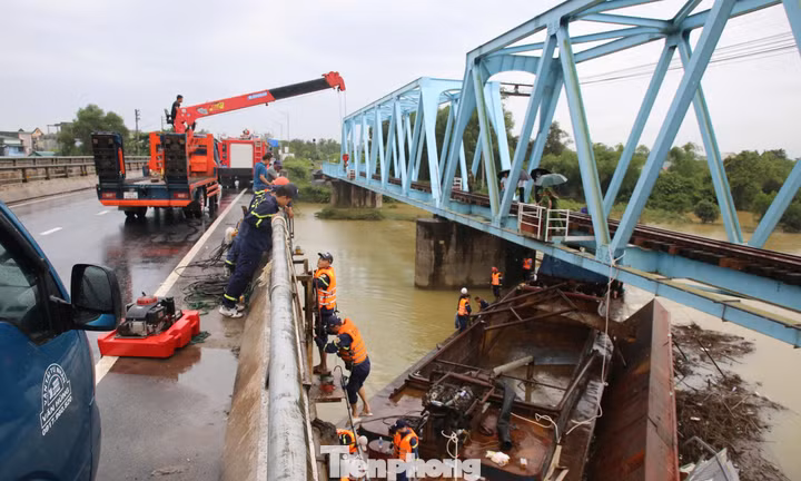 Hàng chục người 'gỡ' sà lan mắc kẹt dưới hai cây cầu ở Quảng Trị