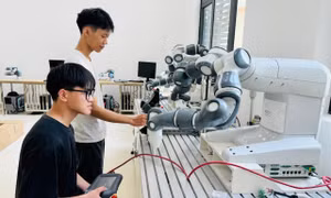 Sinh viên thực hành với cánh tay robot trong phòng Lab Trường ĐH Công nghệ, ĐH Quốc gia Hà Nội. Ảnh: NGHIÊM HUÊ