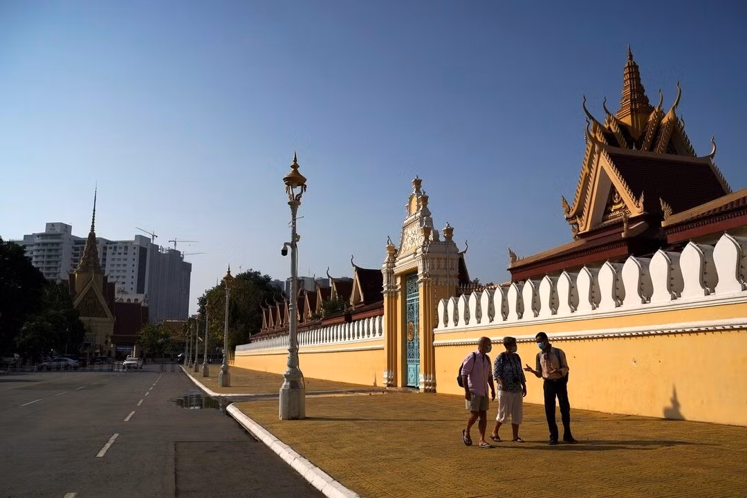 Du khách đi bộ cùng hướng dẫn viên bên ngoài Cung điện Hoàng gia ở Phnom Penh, Campuchia, năm 2020. Ảnh: Reuters.