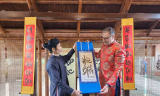 Đại sứ Pháp tại Việt Nam Olivier Brochet tìm hiểu về thư pháp trong chuyến trải nghiệm tại Văn Miếu - Quốc Tử Giám, Hà Nội ngày 23/1Ảnh: Công Hướng