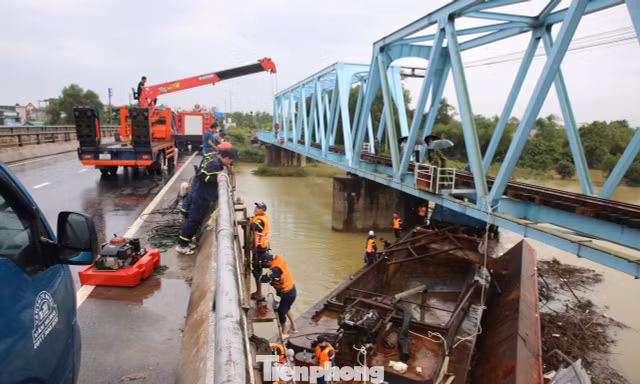 Hàng chục người 'gỡ' sà lan mắc kẹt dưới hai cây cầu ở Quảng Trị