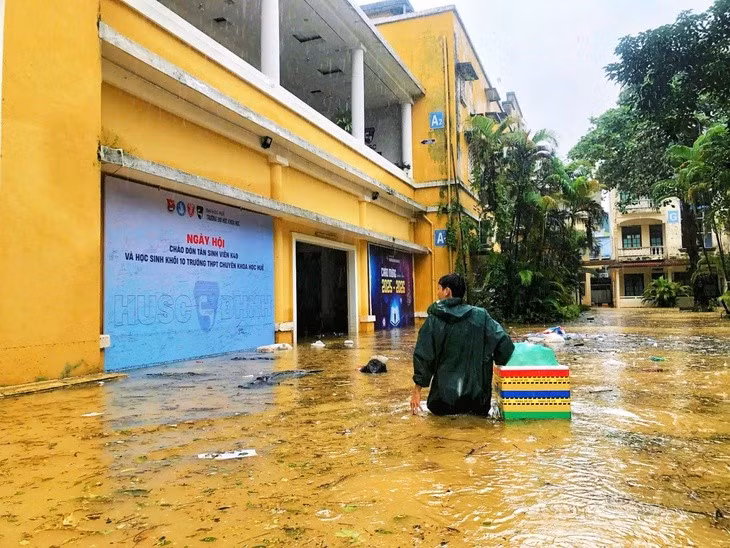 Hình ảnh thầy cô lội nước, mang thức ăn đến tận nơi khiến nhiều sinh viên xúc động, cảm giác như được ở nhà - Ảnh: Hà Trang