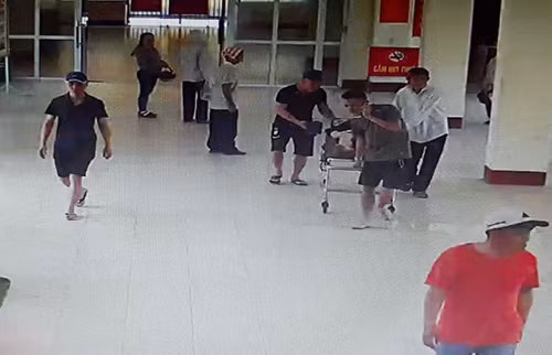 Nhóm người đàn ông đưa thai phụ bị tai nạn giao thông vào làm thủ tục nhập viện. Ảnh: Trích xuất camera