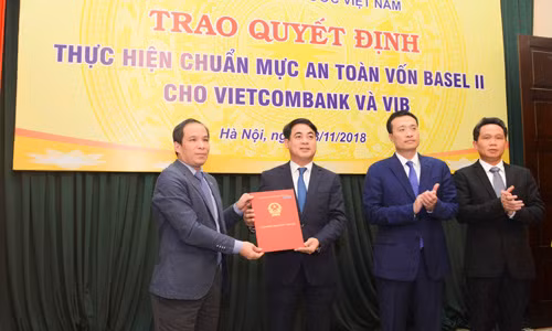 Đại diện Ban Lãnh đạo NHNN, ông Đoàn Thái Sơn – Phó Thống đốc (ngoài cùng bên trái) trao quyết định công nhận Vietcombank thực hiện chuẩn mực an toàn vốn Basel II (đại diện Ban Lãnh đạo Vietcombank nhận quyết định: Ông Nghiêm Xuân Thành – Chủ tịch