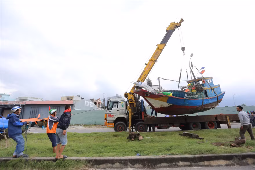 Các chủ tàu đánh cá cẩu tàu thuyền đi trú bão. Ảnh: Giang thanh 
