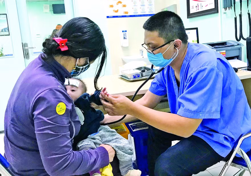 Bác sĩ Hùng khám cho bệnh nhi. Ảnh: Thái Hà 