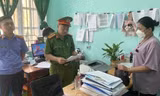 Lực lượng chức năng đọc quyết định khởi tố bị can, bắt tạm giam đối tượng Nông Thị Quỳnh Lan (bìa phải). Ảnh: TL
