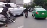 Người đàn ông cầm mã tấu chém rớt hàng loạt gương ô tô. Ảnh cắt từ clip.