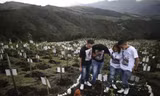 Thân nhân viếng mộ một nạn nhân COVID-19 ở Bogota (Colombia). Ảnh: AP