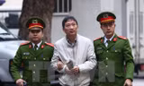 Cảnh sát dẫn giải bị cáo Trịnh Xuân Thanh, nguyên Chủ tịch Hội đồng quản trị, Tổng giám đốc Tổng Công ty Cổ phần Xây lắp dầu khí Việt Nam - PVC đến tòa. (Ảnh: Doãn Tấn/TTXVN)