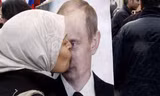 Một phụ nữ Syria hôn ảnh chân dung của Tổng thống Putin trong cuộc tuần hành ủng hộ chính phủ ở thủ đô Damascus. Ảnh: AP