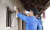 Sinh viên tình nguyện sửa điện giúp gia đình thương binh. Ảnh: Nguyễn Thắng