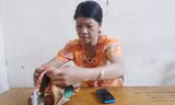 Chị Nguyễn Thị Hán mở lại chiếc khăn đã dùng để bọc gói bật lửa.