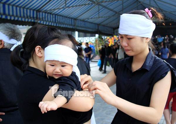 Người nhà thắt khăn tang cho con trai đồng chí Đỗ Mạnh Uy. Ảnh: Trường Phong