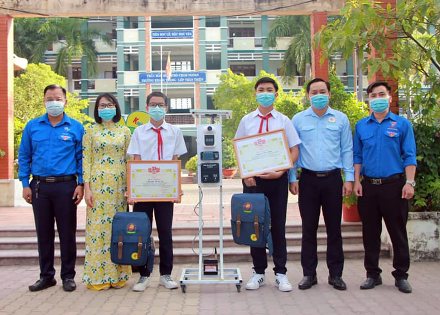 Anh Trần Bảo Lâm - Phó Bí thư Tỉnh Đoàn, Chủ tịch Hội đồng Đội tỉnh Bình Dương biểu dương trao khen thưởng cho hai tác giả bên cạnh sáng chế thiết bị "3 trong 1". Ảnh: TĐBD