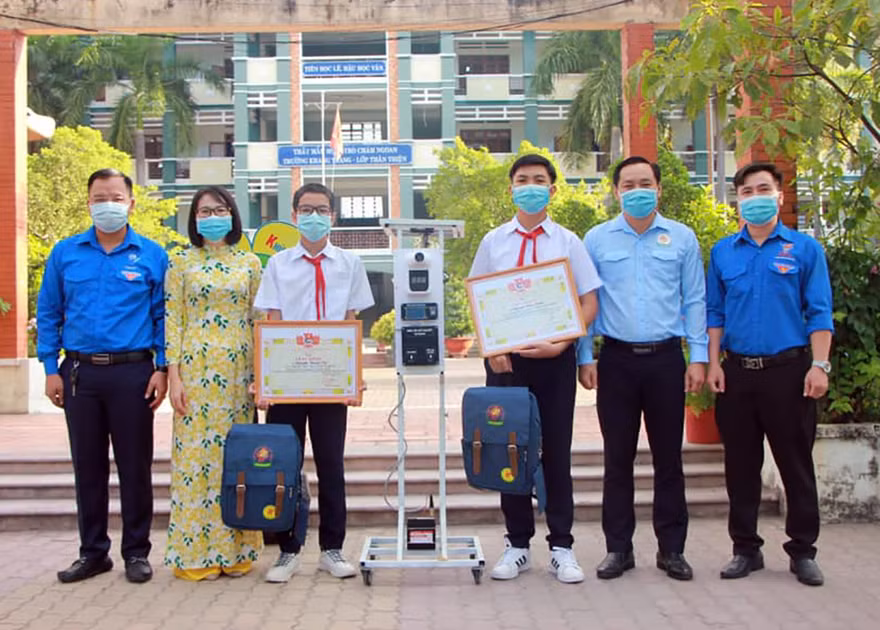 Anh Trần Bảo Lâm - Phó Bí thư Tỉnh Đoàn, Chủ tịch Hội đồng Đội tỉnh Bình Dương biểu dương trao khen thưởng cho hai tác giả bên cạnh sáng chế thiết bị "3 trong 1". Ảnh: TĐBD