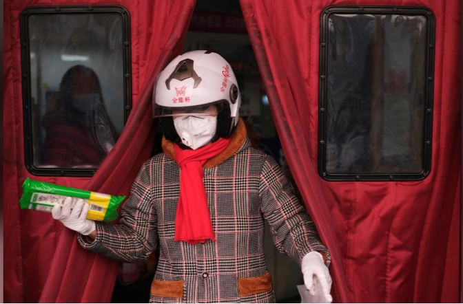 Một phụ nữ bước ra từ siêu thị ở Bắc Kinh, nơi cũng đang chống chọi với virus corona Vũ Hán