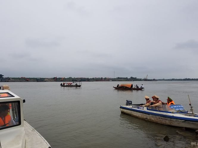 Cảnh sát và người dân cùng tìm kiếm nữ sinh trên sông Đuống.