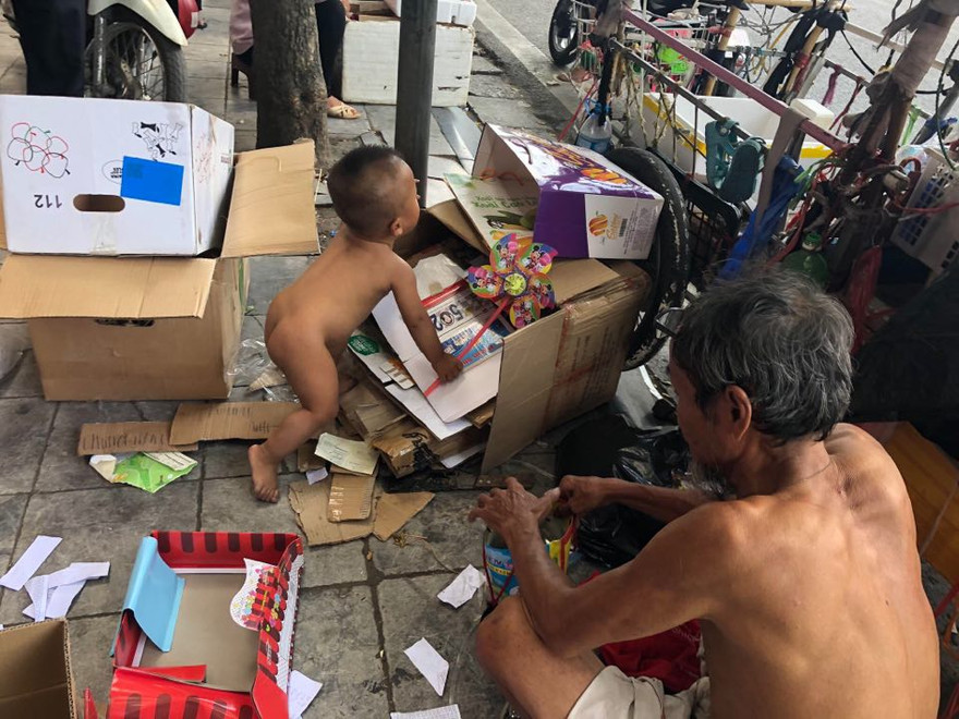 Ông Lê Thanh Toàn và cháu bé 18 tháng tuổi cùng kiếm sống trên đường phố.
