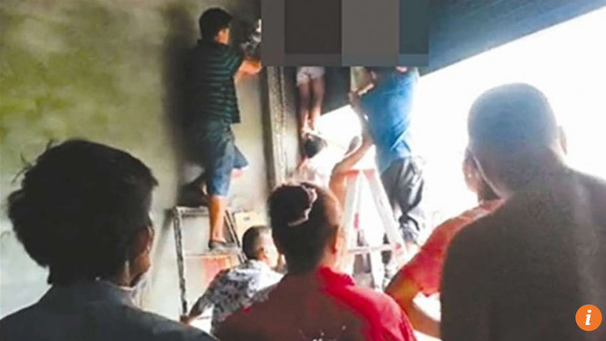 Dân làng phải mất 1 tiếng đồng hồ để gỡ hai em ra khỏi chiếc cửa cuốn