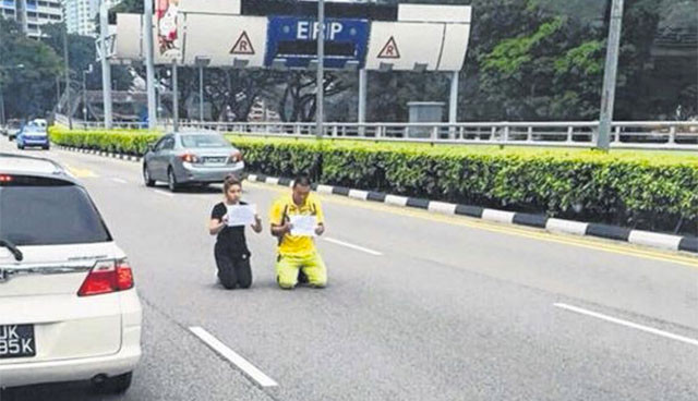Cặp đôi quỳ gối giữa đường bất chấp xe cộ qua lại.
