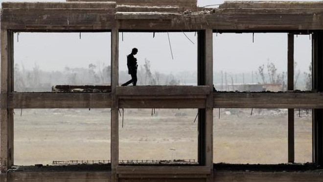 Mộ binh sỹ chính phủ Iraq kiểm tra một toà nhà ở ngoại ô Falluja, Iraq, nơi đang có giao tranh ác liệt giữa quân chính phủ và IS.