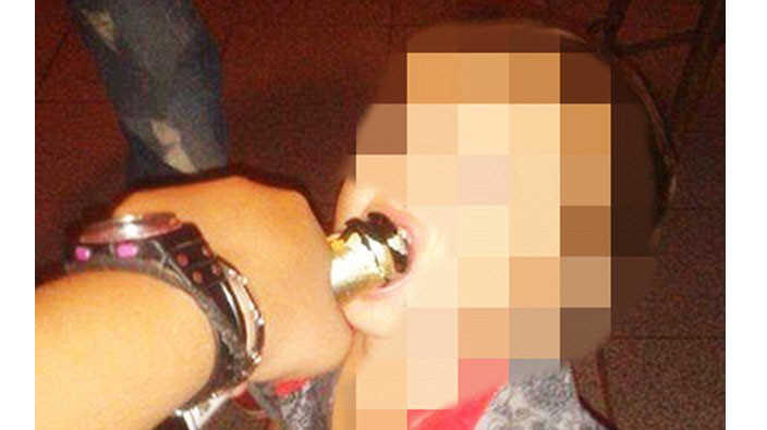 Một bức ảnh cho thấy em bé bị đổ rượu vào miệng.