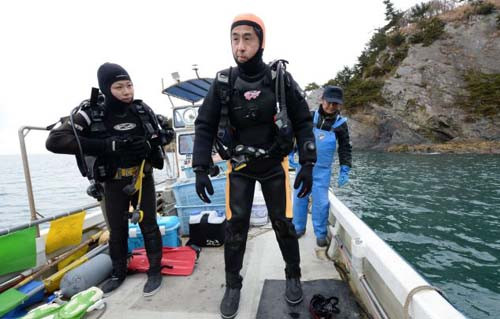 Ông Takamatsu chuẩn bị lặn xuống biển trước ngày kỷ niệm ba năm thảm họa kép ở Nhật Bản vào năm ngoái. Ảnh: AFP.