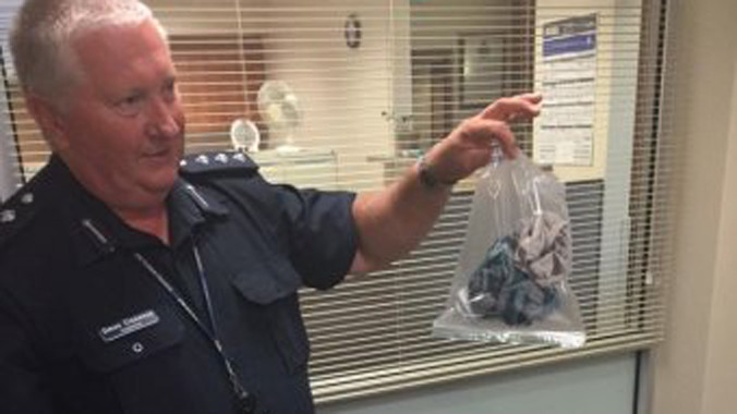 Điều tra viên Clemence cầm trong tay "quả bom" lấy ra từ chiếc vali.