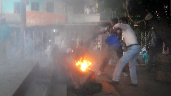 Những người xung quanh cố gắng dập lửa (Ảnh: CNN)