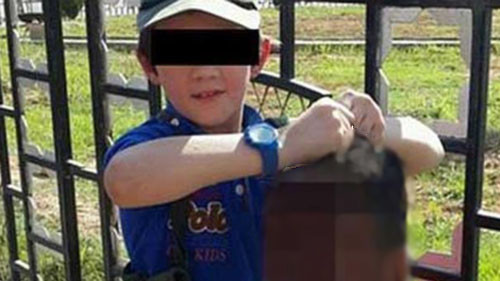 Cậu bé tươi cười nắm thủ cấp của một binh sỹ Syria