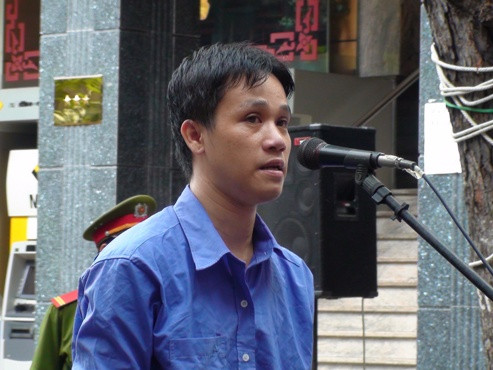 Bị cáo Lê Minh Khương trong phiên tòa xét xử lưu động sáng nay. Ảnh T.Châu