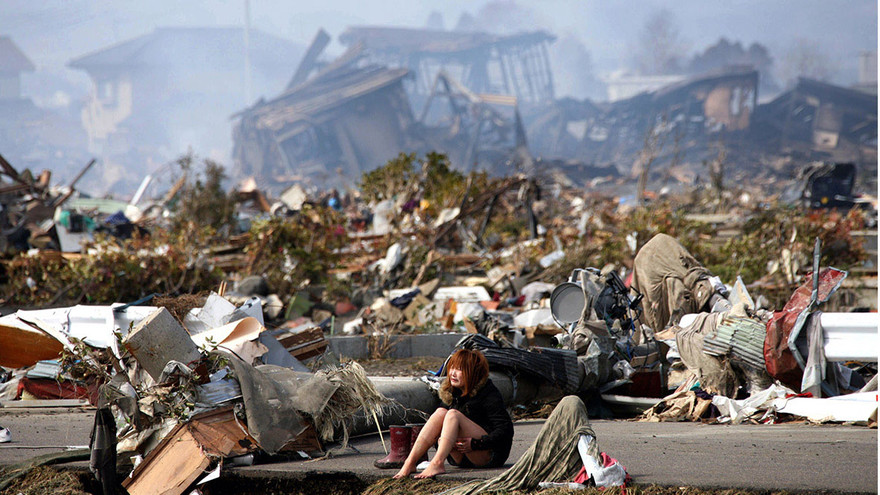 Cô gái ngồi khóc giữa cảnh hoang tàn đổ nát ở thành phố Natori, tỉnh Miyagi