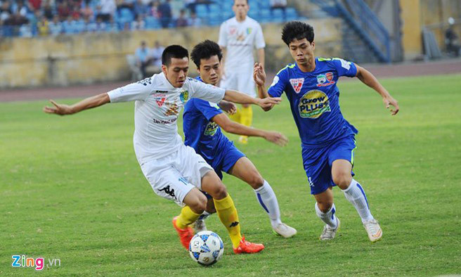 HAGL (áo xanh) quỵ ngã trên sân Hàng Đẫy của Hà Nội T&T.