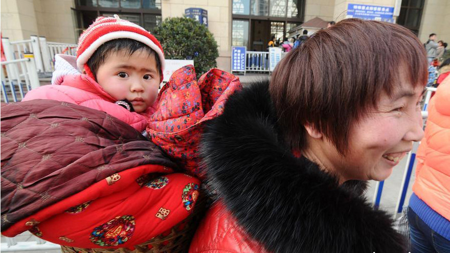 Em bé trên lưng mẹ về quê ăn Tết