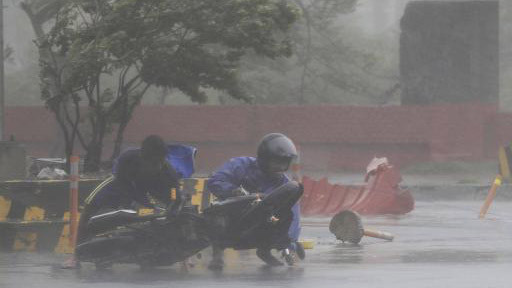 Người đi xe máy bị bão Thần Sấm quật ngã ở Manila