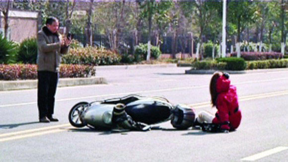 Ông Gouhua Zhao giơ điện thoại chụp ảnh vụ tai nạn