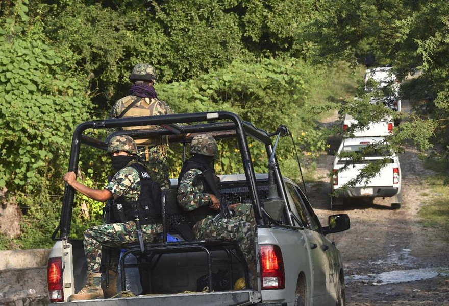 Binh lính Mexico hộ tống các chuyên gia pháp y đến hiện trường các hố chôn tập thể