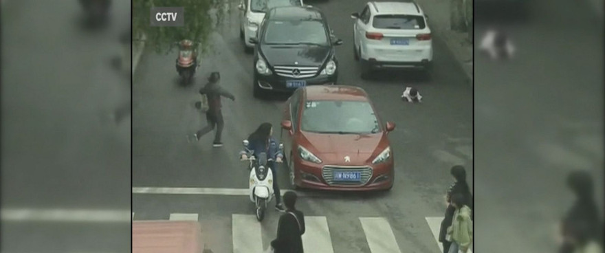 Em bé ngã sấp mặt lọt gầm chiếc xe màu trắng.