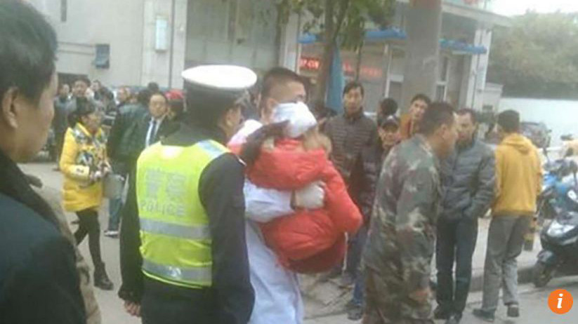 Các nhân viên y tế đưa một em nhỏ bị thương ở đầu lên xe cấp cứu.