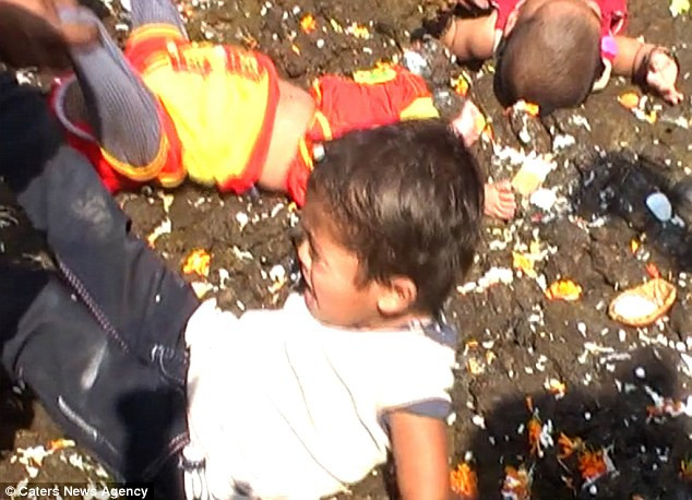 Trẻ em được lăn qua phân bò. Ảnh: Dailymail