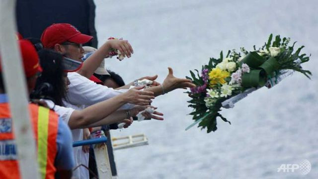 Người thân ném hoa tưởng nhớ các nạn nhân. 