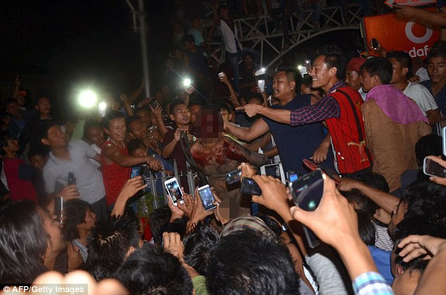 Đám đông vây quanh nghi can hiếp dâm