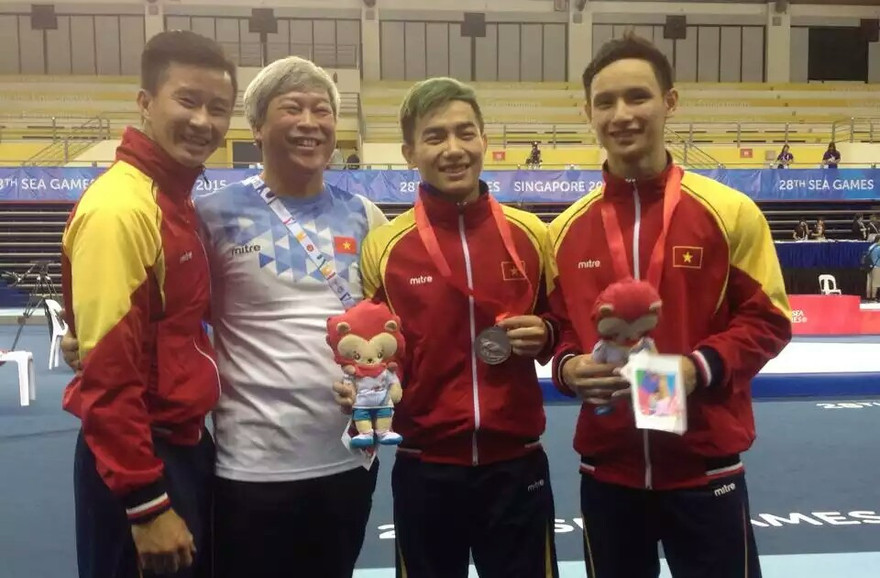 Đinh Phương Thành (trái) chụp ảnh chia vui cùng các đồng đội và HLV.