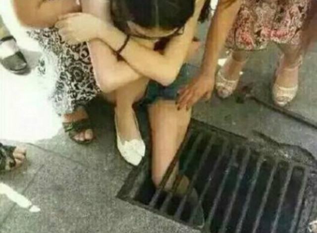 Mải mê dùng điện thoại, cô gái mắc kẹt ở nắp cống