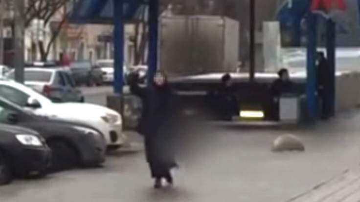 Bảo mẫu áo đen cầm đầu của em bé diễu phố. Ảnh cắt từ clip.